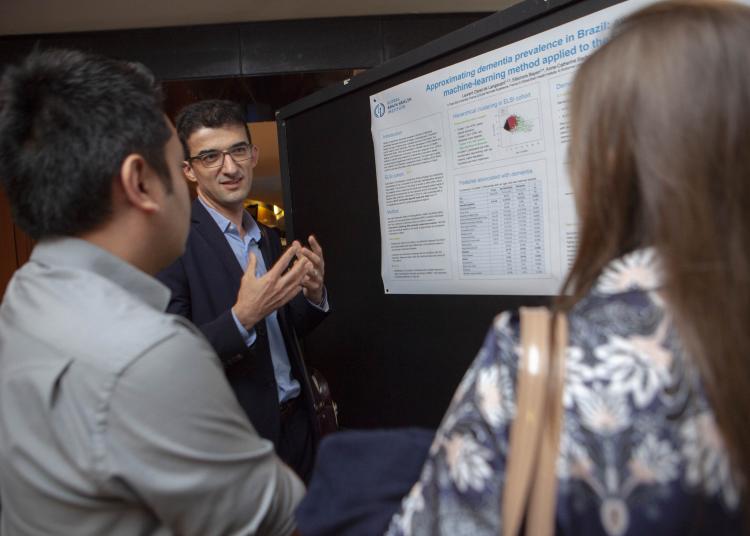 Atlantic Fellow Laurent Cleret presenting his poster to two people